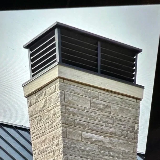 Close-up of a chimney with a black metal cap on top.