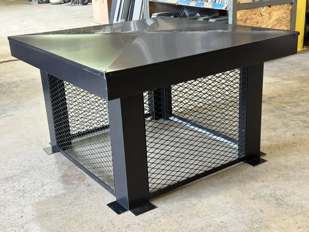 A black aluminum chimney shroud with screened sides.
