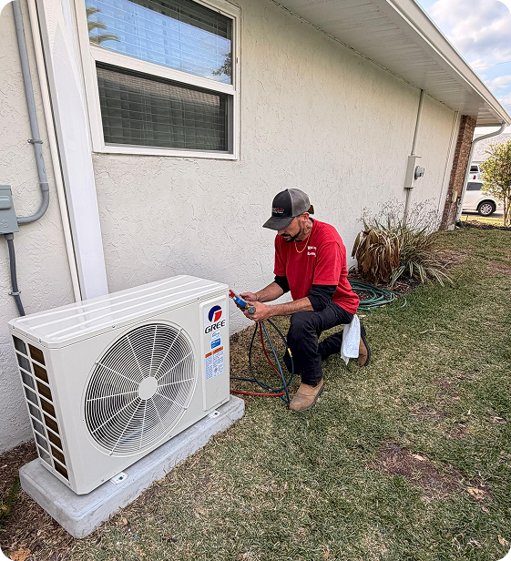 HVAC technician inspecting or servicing an outdoor air conditioning unit outside a house.