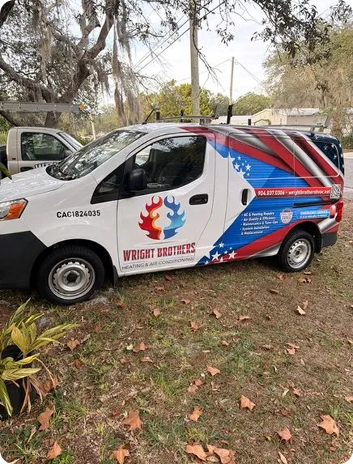 Commercial van with patriotic red, white, and blue design and a logo of a flame in the shape of a drop with a star, advertising Wright Brothers Heating & Air Conditioning, parked on grass and surrounded by fallen leaves.