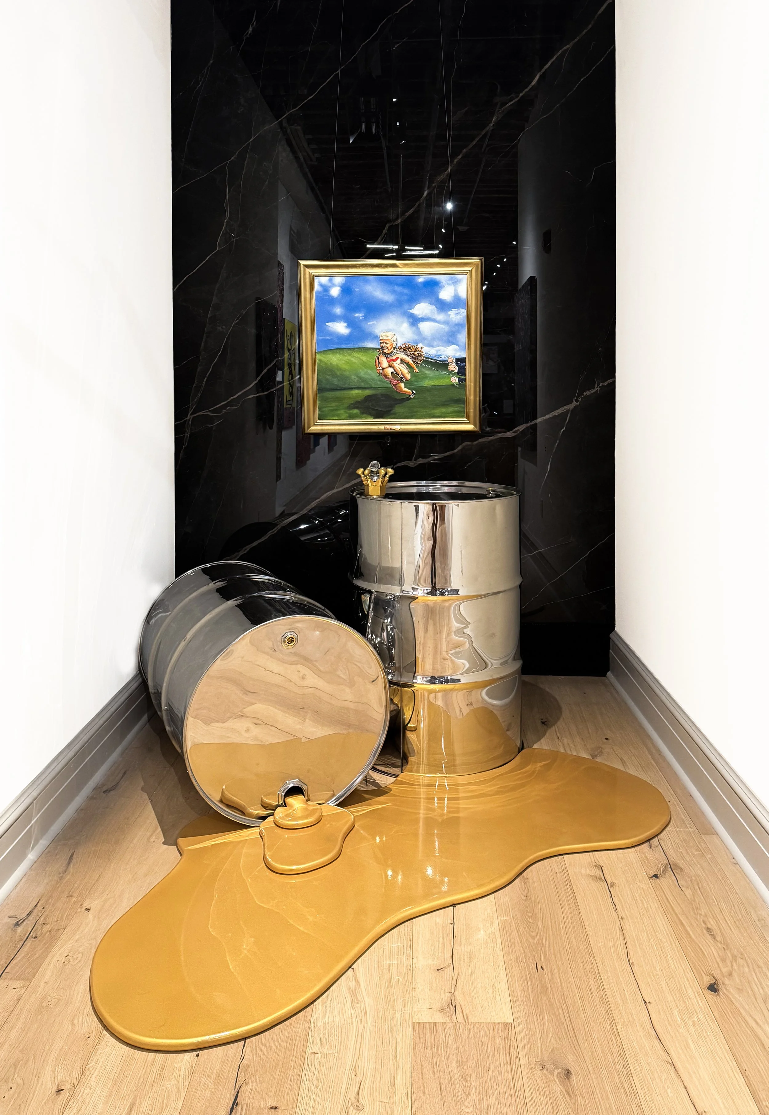 A metallic sculpture resembling a stream with a reflective surface, placed on a wooden floor, with a painting of a cartoonish character running in a grassy landscape behind it. The sculpture includes elements that mimic water and a small fountain.