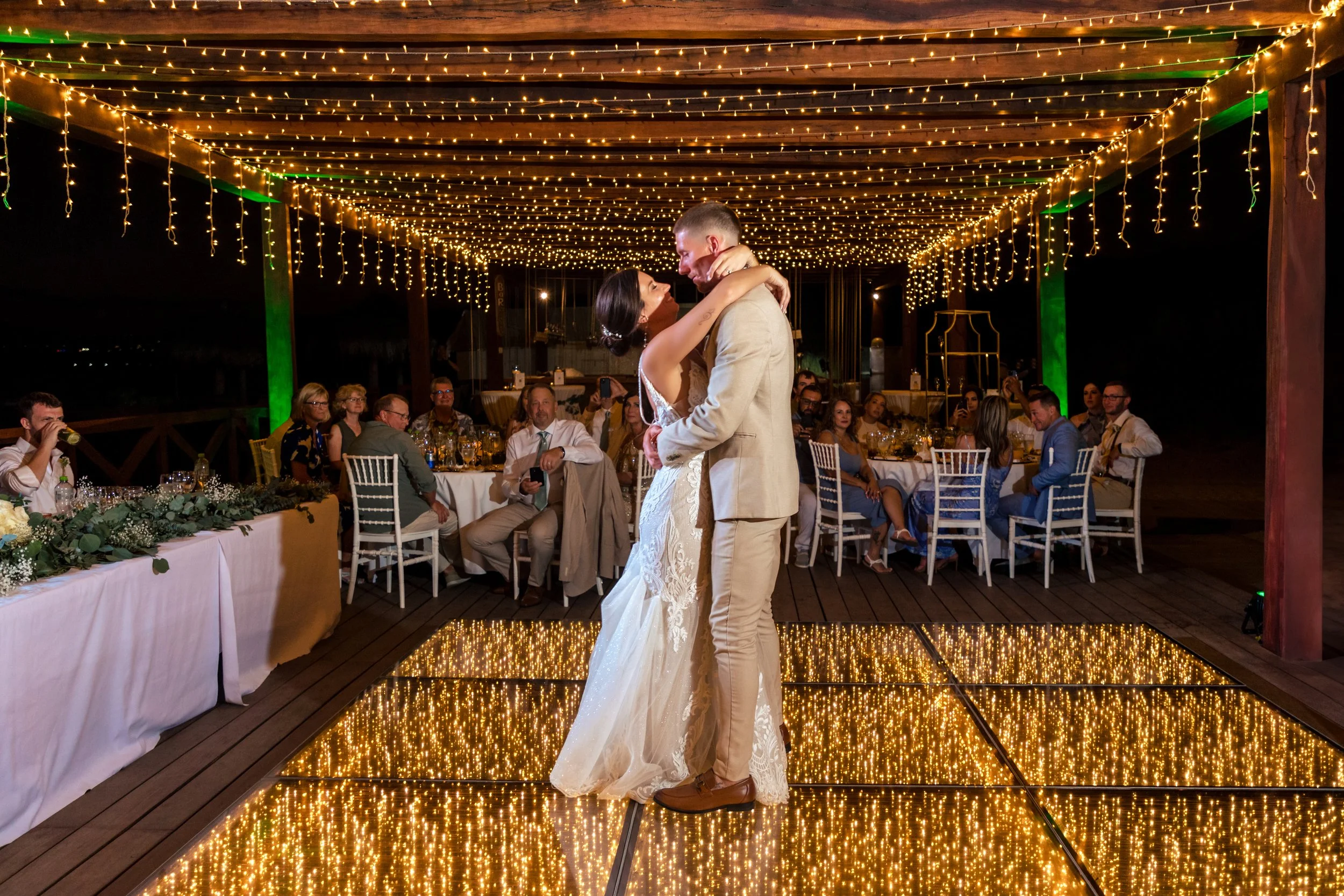 Wedding reception in Los Cabos with string lights, dance floor lighting, decorated tables, and ambient event styling by I DO Weddings Los Cabos.