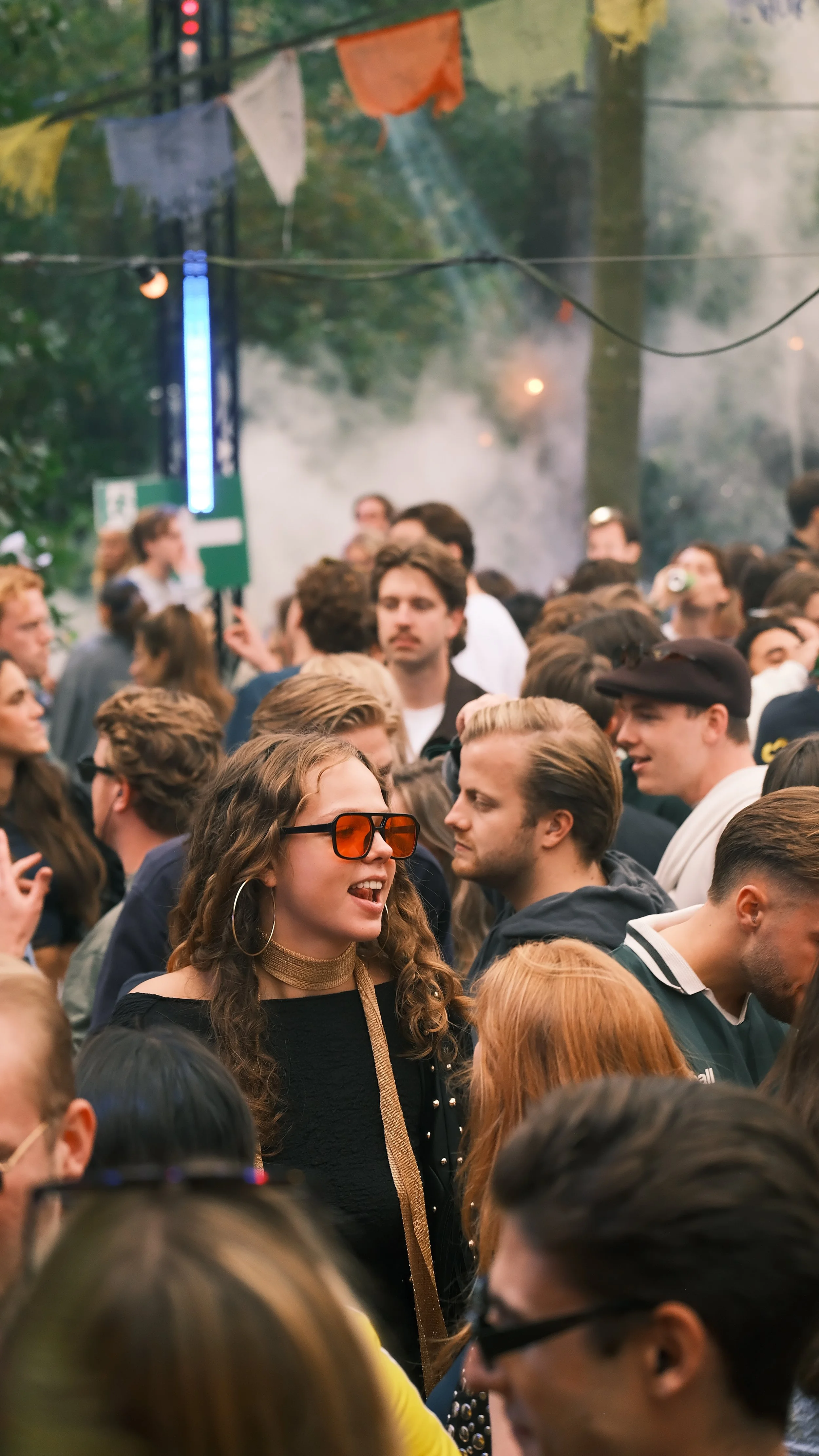 Mensen ontmoeten elkaar op een druk evenement in een bosrijke omgeving.