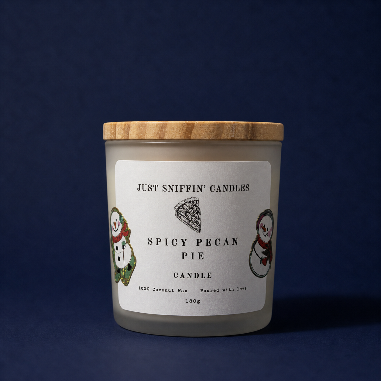 A candle container labeled 'Just Sniffin' Candles Spicy Pecan Pie Candle' with a wooden lid, decorated with holiday-themed snowman stickers, set against a dark blue background.