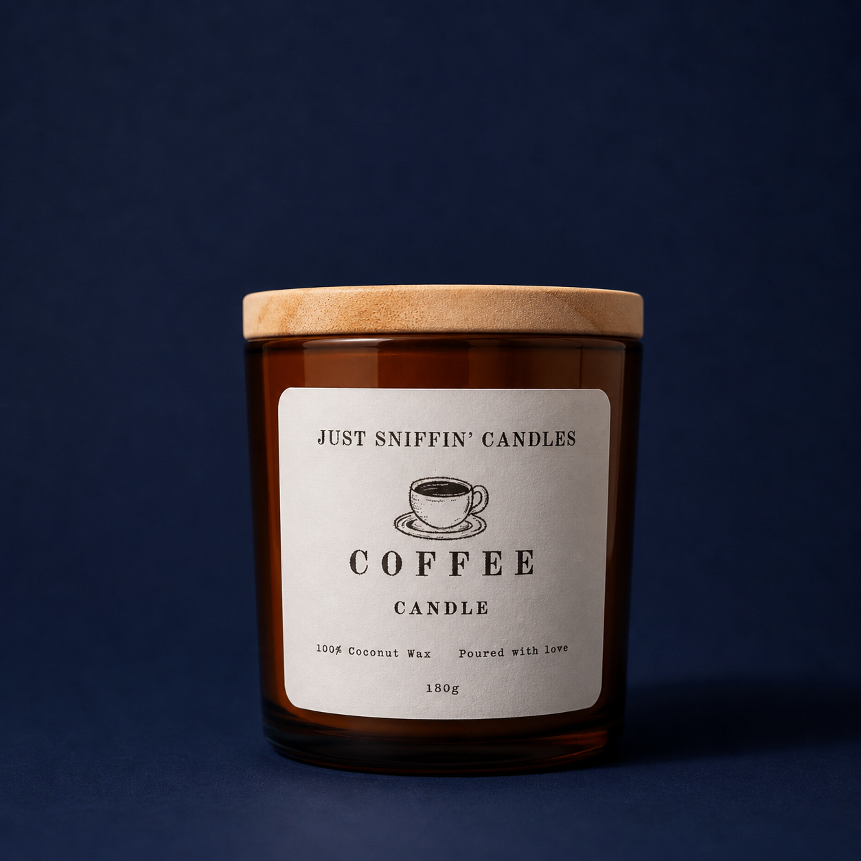 A brown glass candle with a wooden lid, labeled "Just Sniffin' Candles Coffee Candle," featuring a sketch of a coffee cup, and text indicating it is made of 100% coconut wax, poured with love, weighing 180 grams.