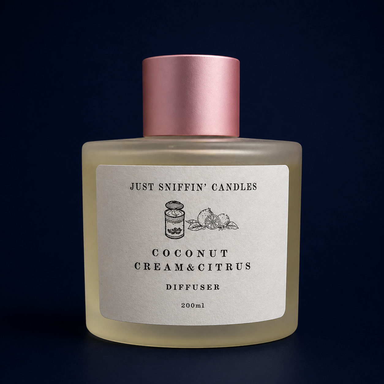 A frosted glass diffuser with a pink cap, labeled 'Just Sniffin' Candles, Coconut Cream & Citrus,' set against a dark background.