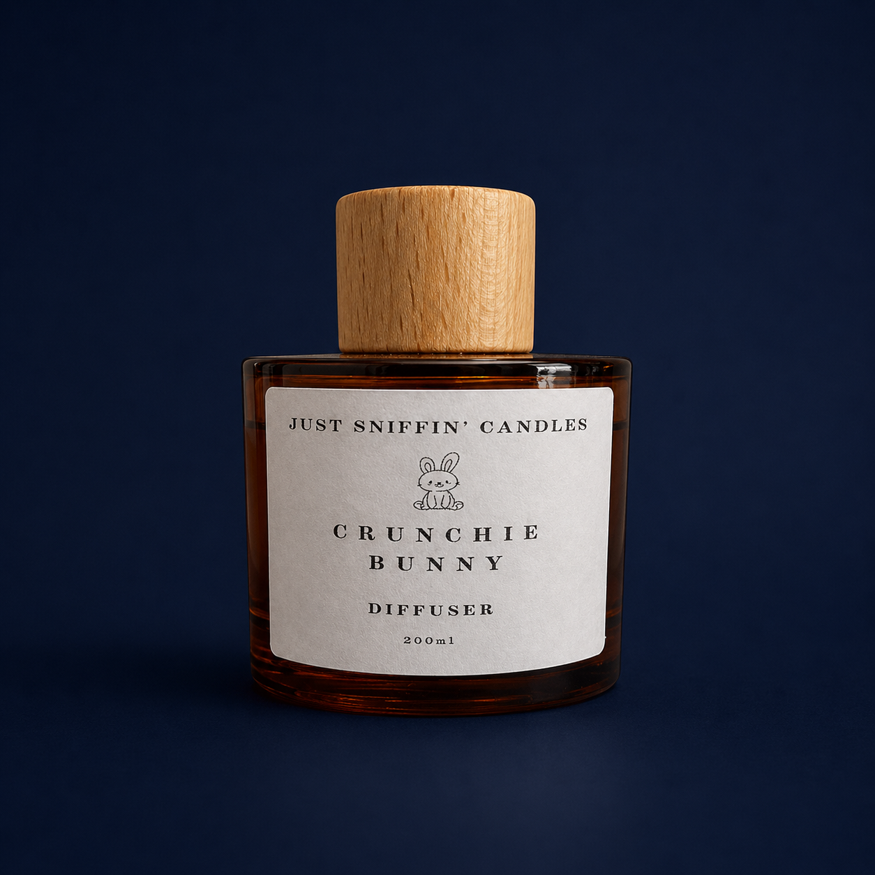 A brown glass candle jar with a wooden lid, labeled "Just Sniffin' Candles, Crunchie Bunny Diffuser, 200ml", set against a dark blue background.