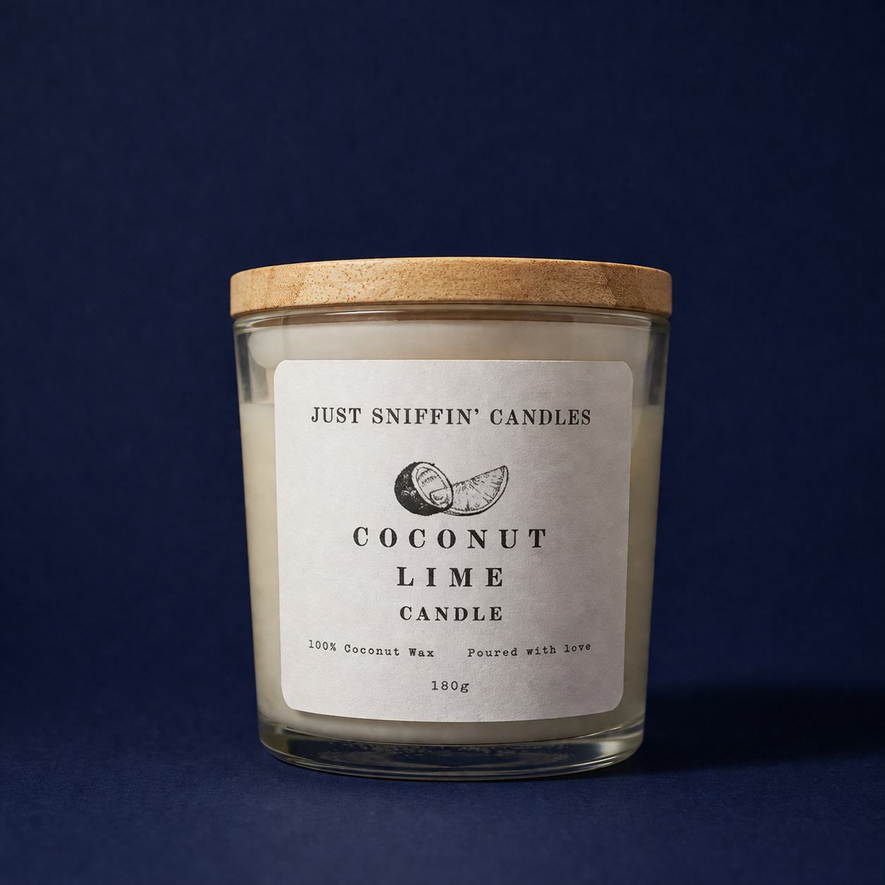 A candle in a glass jar with a wooden lid, labeled 'Just Sniffin' Candles, Coconut Lime Candle,' against a dark blue background.