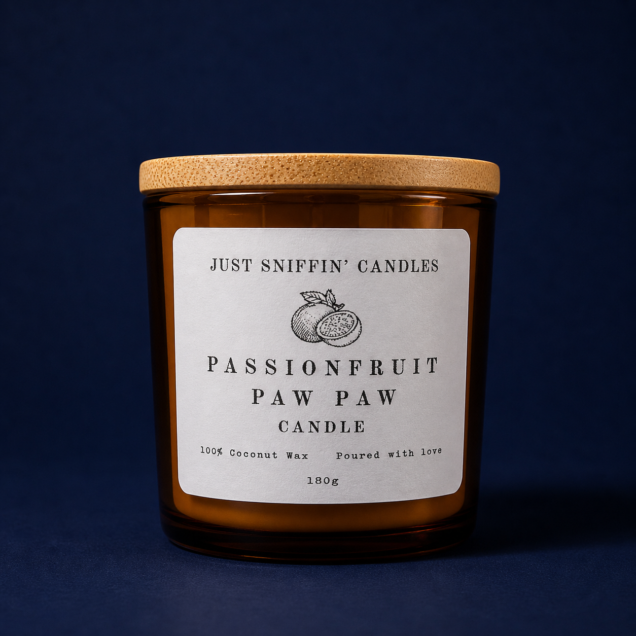 A brown candle jar with a wooden lid and a white label that reads 'Just Sniffin' Candles Passionfruit Paw Paw Candle' with an illustration of a passionfruit. The label also states '100% Coconut Wax' and 'Poured with love' and indicates the weight as 180 grams.