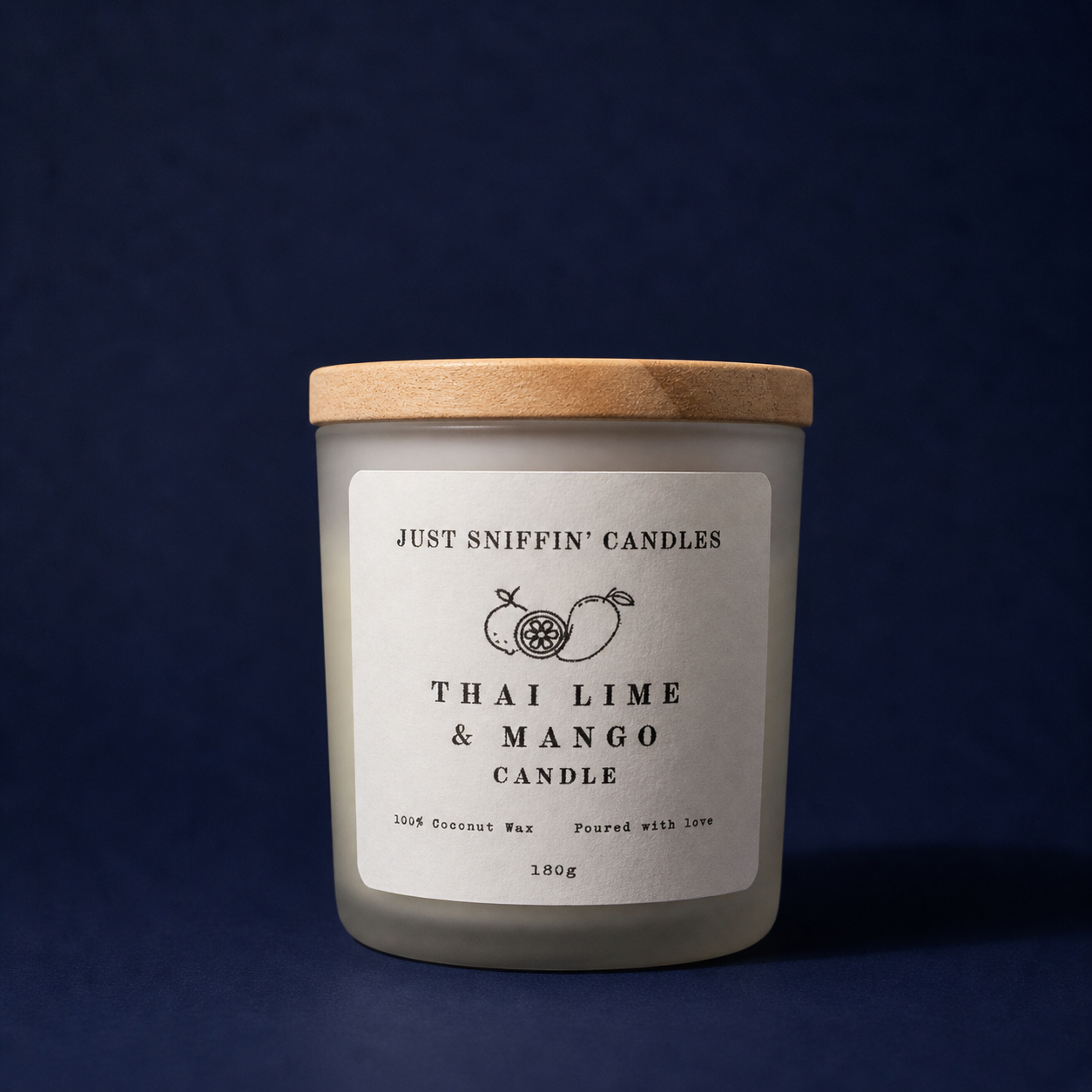 A candle labeled "Just Sniffin' Candles" with the scent "Thai Lime & Mango" in a frosted glass container with a wooden lid, set against a dark background.