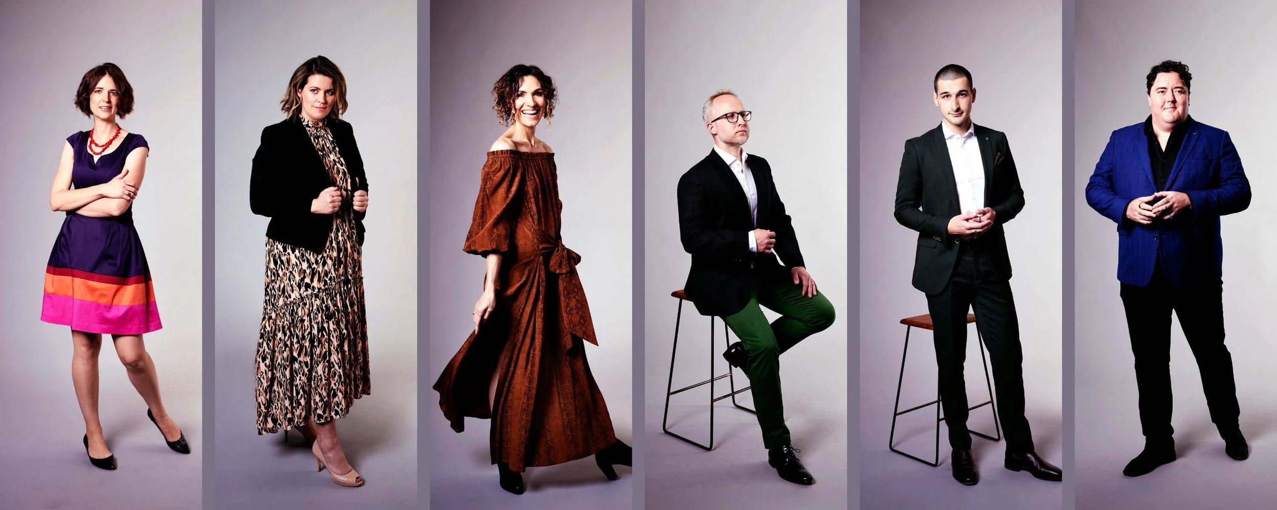 Group of six professionally dressed individuals posing against a plain background.