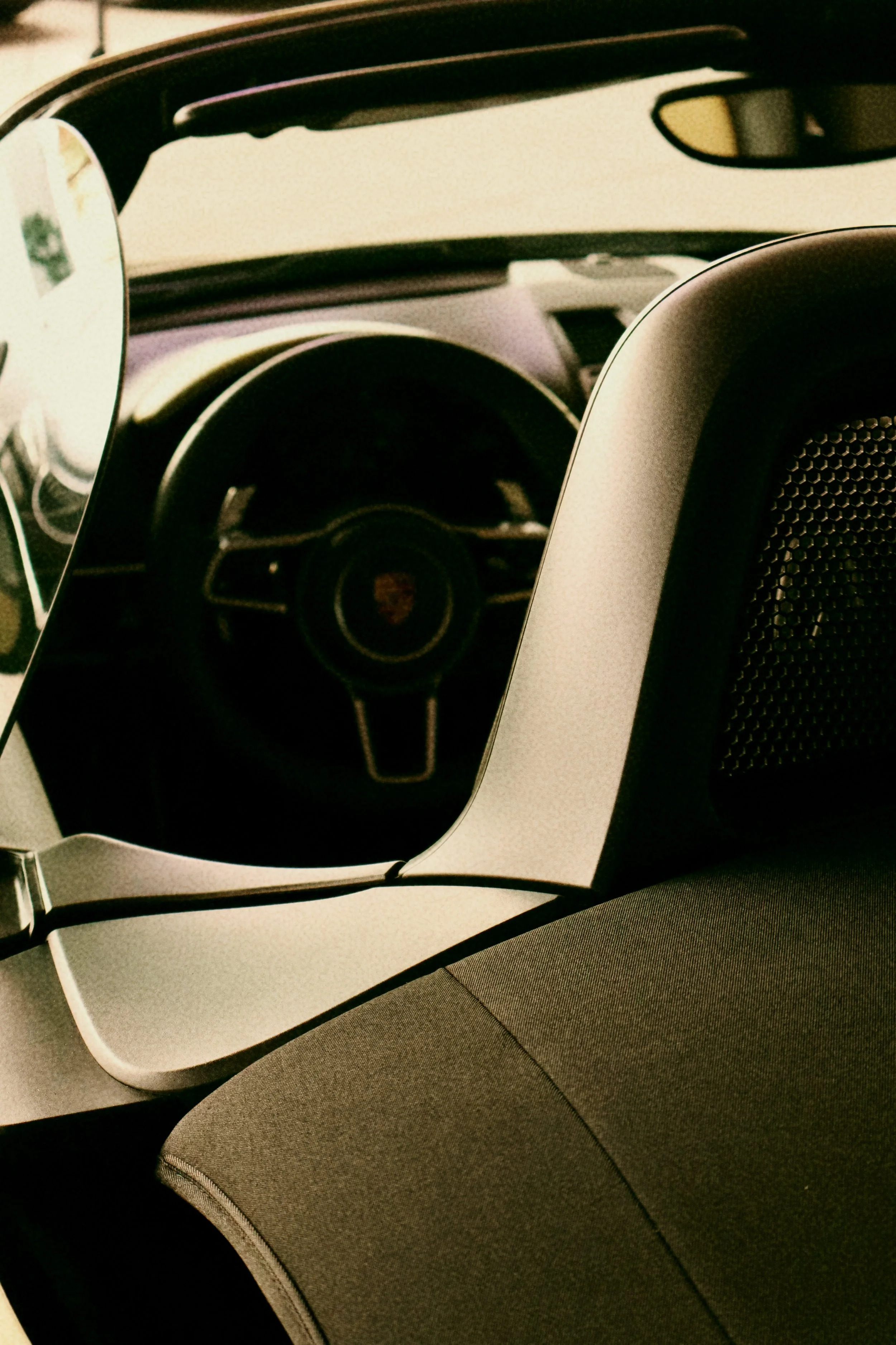 Interior of a car with a steering wheel, rearview mirror, and seat, viewed through a reflective visor.