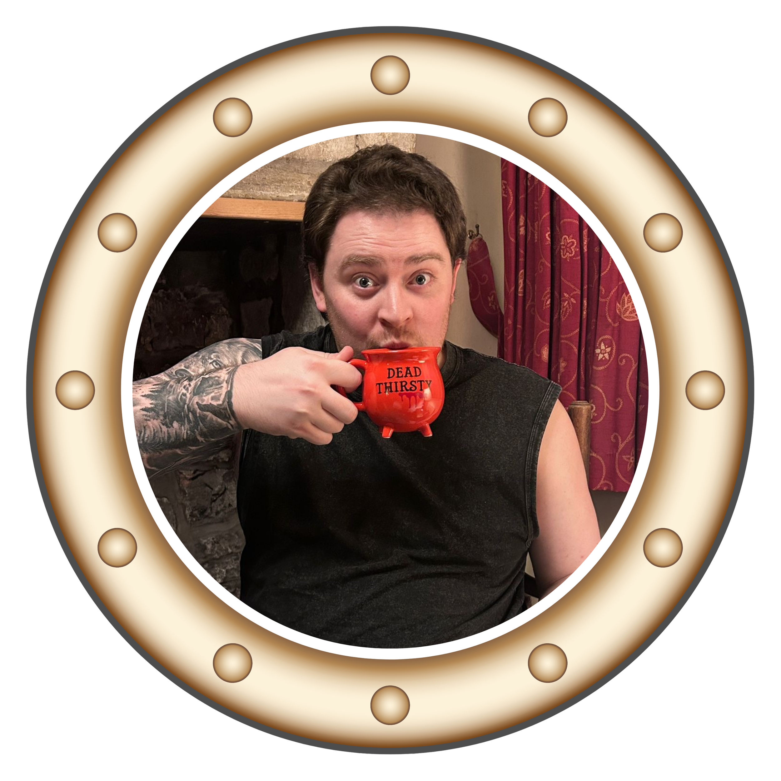A person with tattoos on their arm holding a red mug labeled 'Dead Thirsty', smiling and looking at the camera, in front of a decorative mirror with light bulbs around its border.