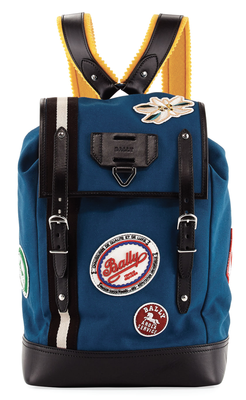 Teal and yellow backpack with an embroidered floral appliqué and badges