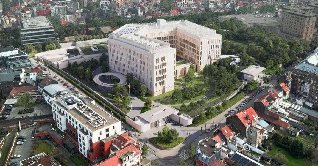 Vue aérienne d'un bâtiment moderne blanc avec un jardin vert entouré d'une zone urbaine.