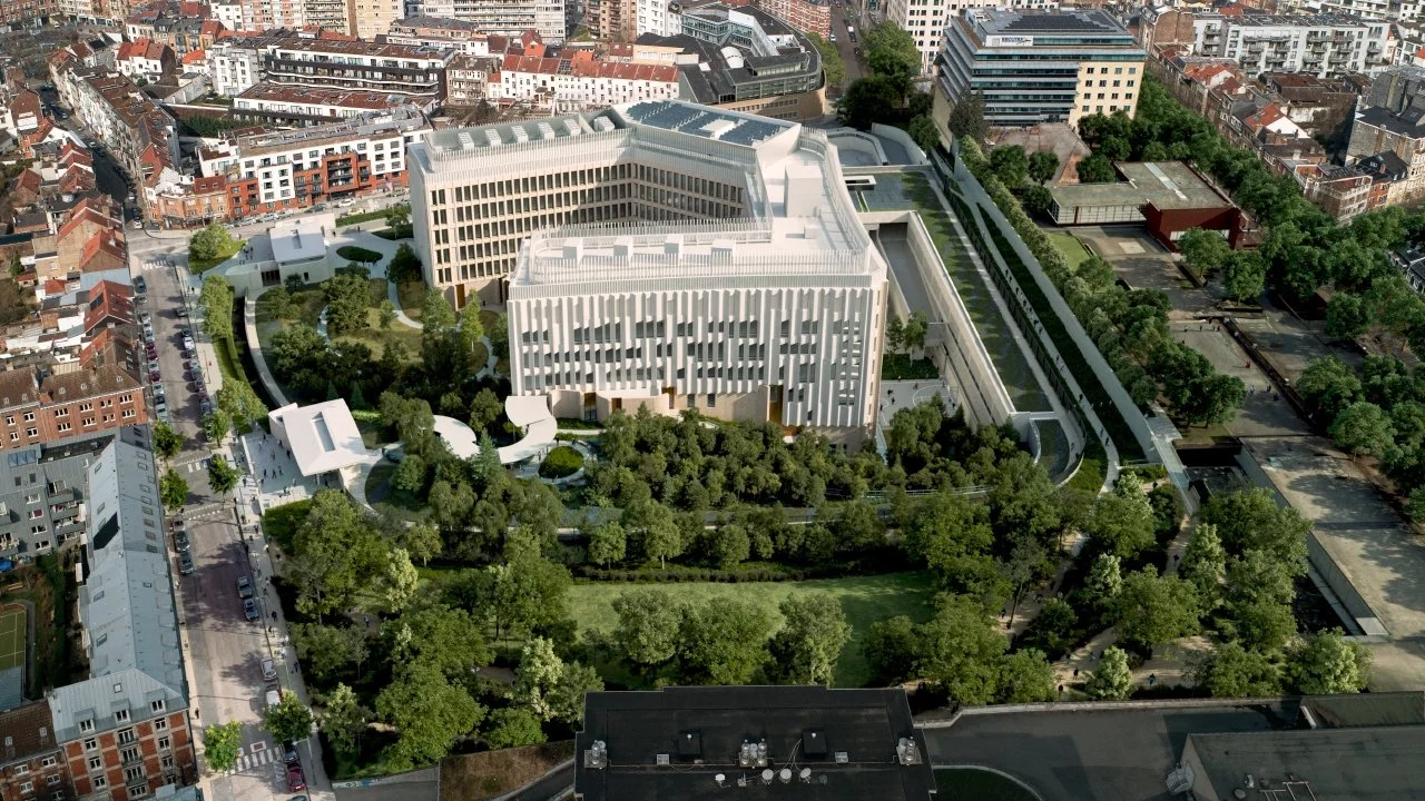Vue aérienne d'un complexe moderne entouré de jardins et d'immeubles résidentiels dans une zone urbaine.