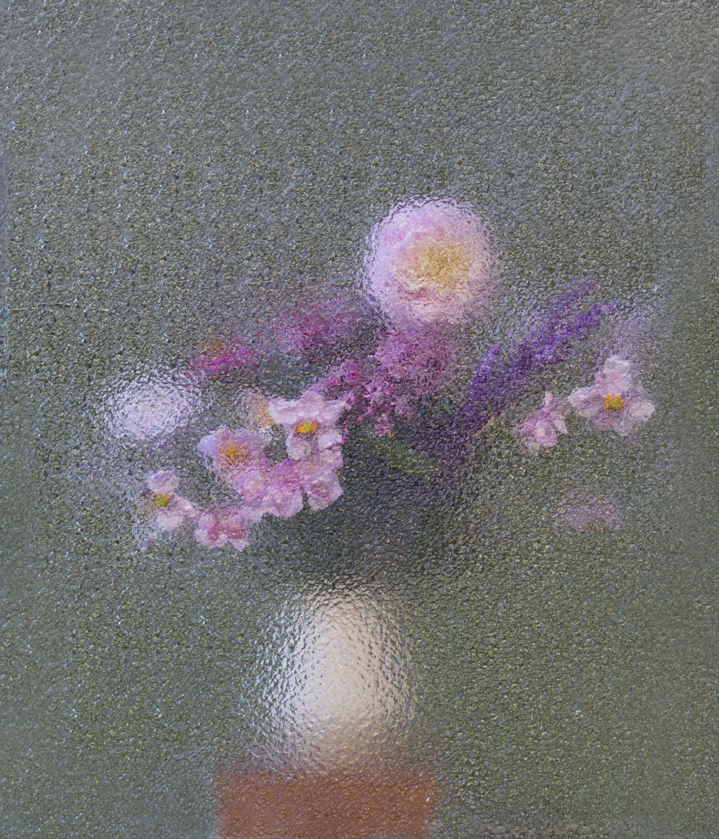 Colorful spray paint markings on a dark textured surface.