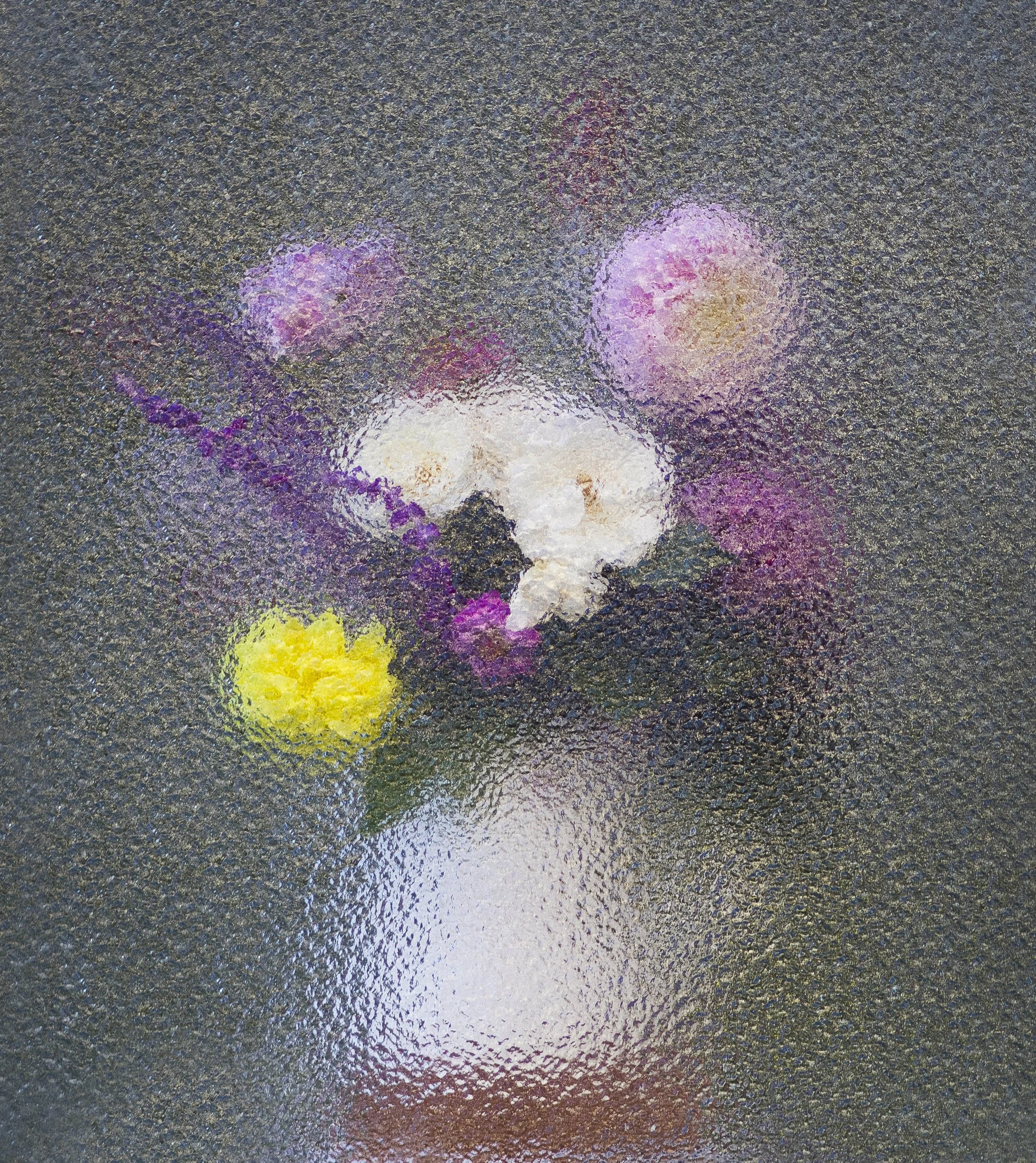 Colorful sidewalk chalk marks on a wet, textured asphalt surface, creating abstract and blurred shapes and lines in shades of pink, purple, white, yellow, and orange.
