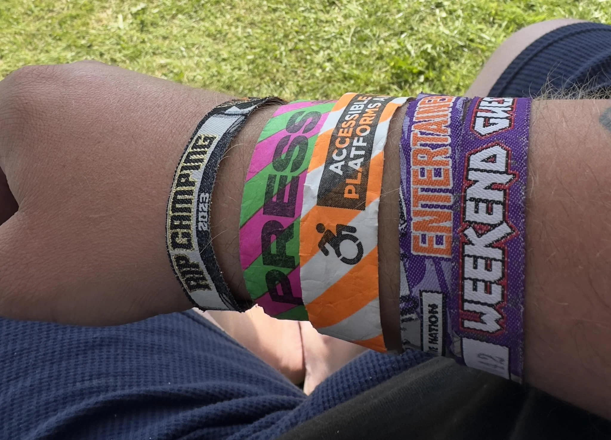An arm covered with festival wristbands
