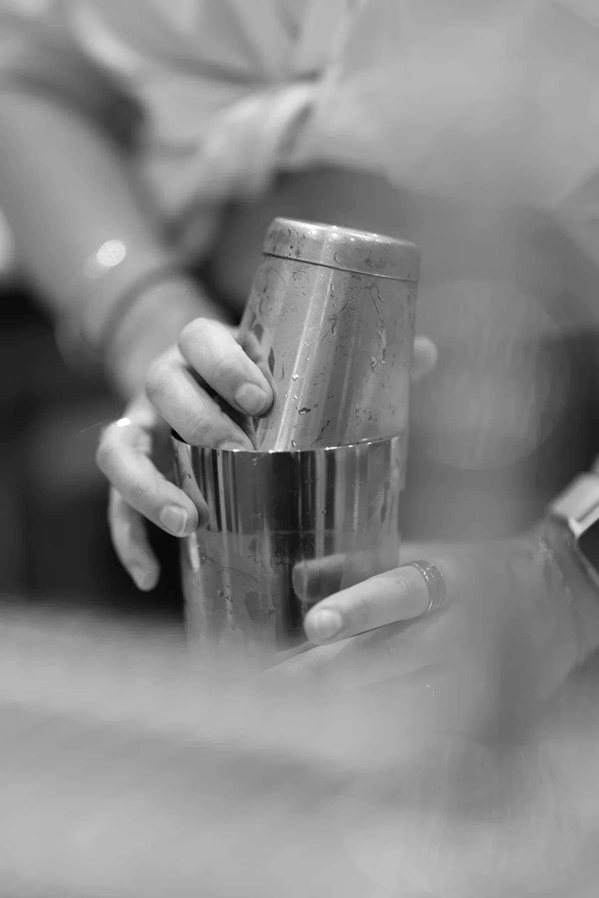 Une personne manipule un cocktail dans un shaker, en utilisant une cuillère à cocktail.