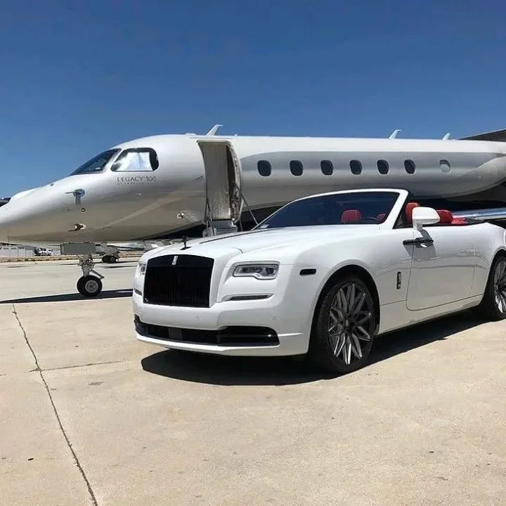 Sarasota Motor Club - Exotic Car Rental Sarasota - A white convertible luxury Rolls Royce parked on an airport tarmac with a private jet in the background.