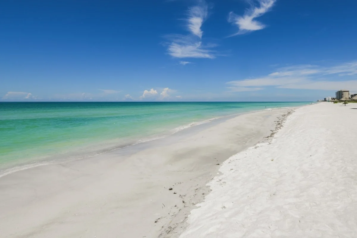 Sarasota Motor Club - Sports Car Rental Sarasota FL - Empty white sandy beach with turquoise water and a clear blue sky.
