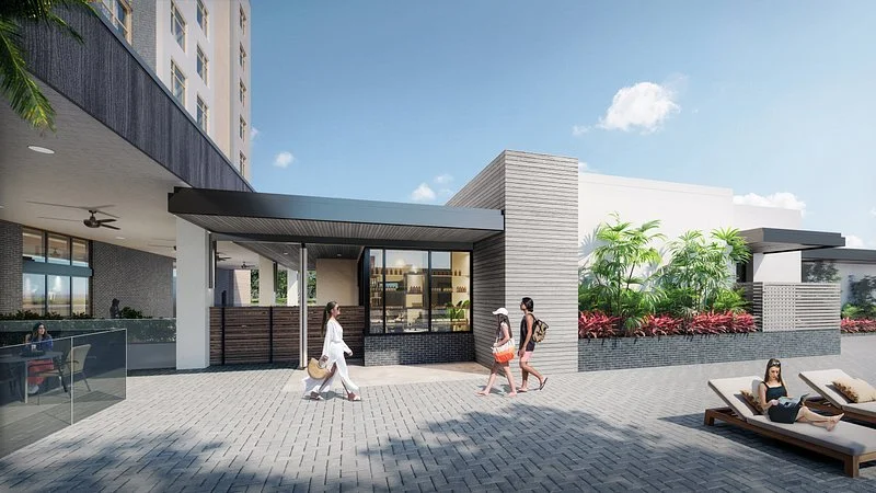 Sarasota Motor Club - Palmetto Marriott luxury car rental - People walking past a modern building with outdoor seating and lounge chairs under a clear sky.