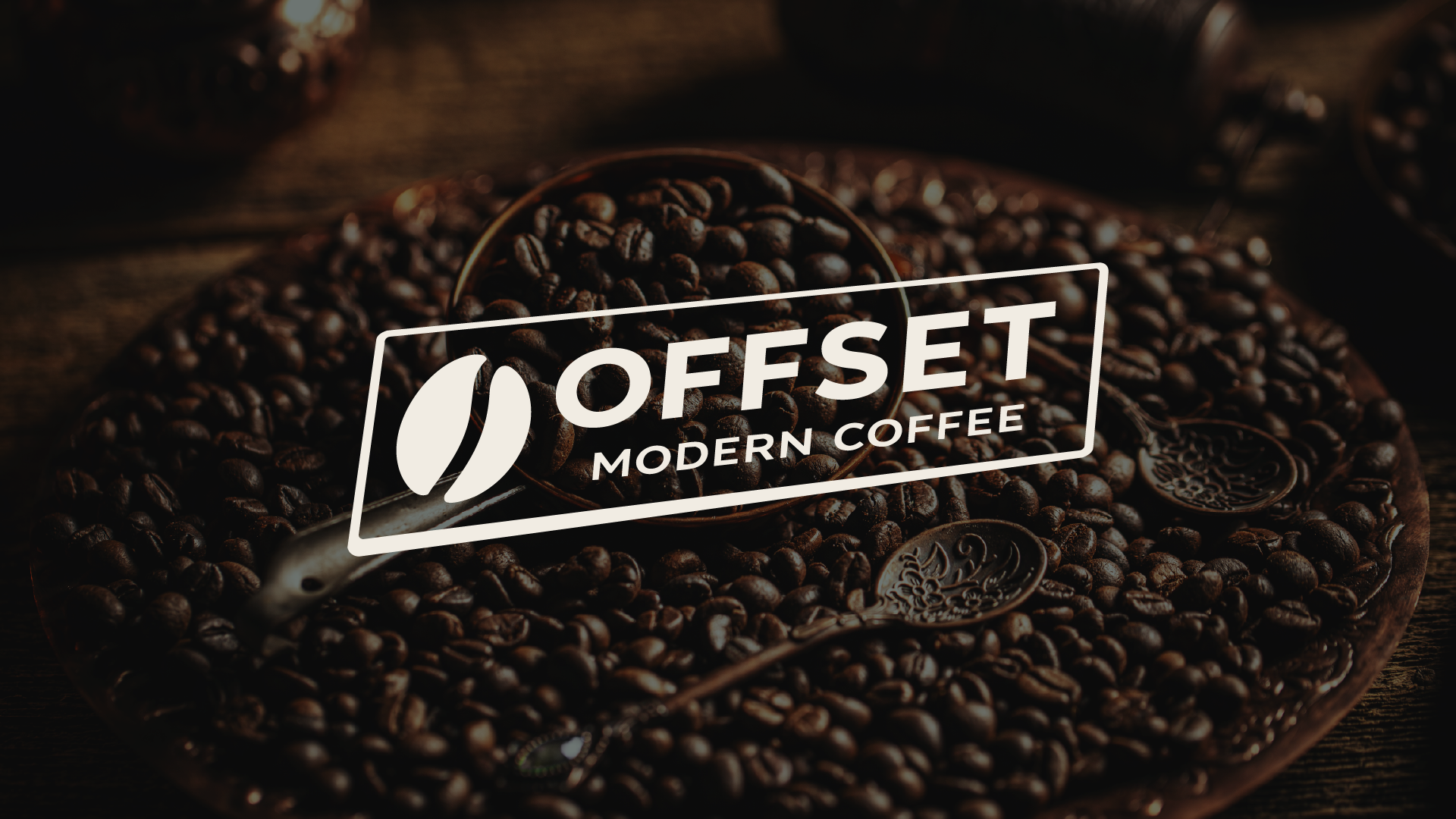 Close-up of roasted coffee beans in a bowl with a spoon, branded with Offset Modern Coffee logo.