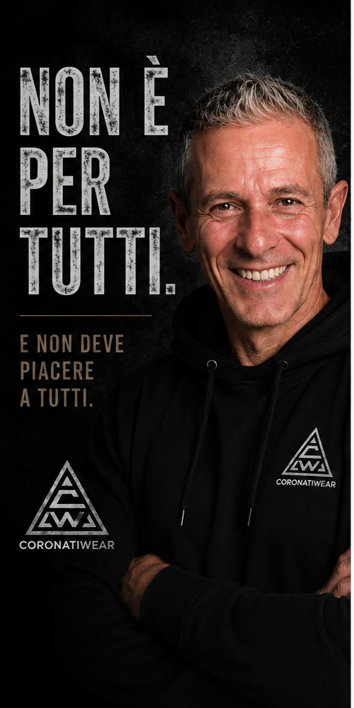 Uomo sorridente con felpa nera con logo 'CORONATIWEAR', sfondo nero, testo in italiano: 'NON È PER TUTTI. E NON DEVE PIACERE A TUTTI.'