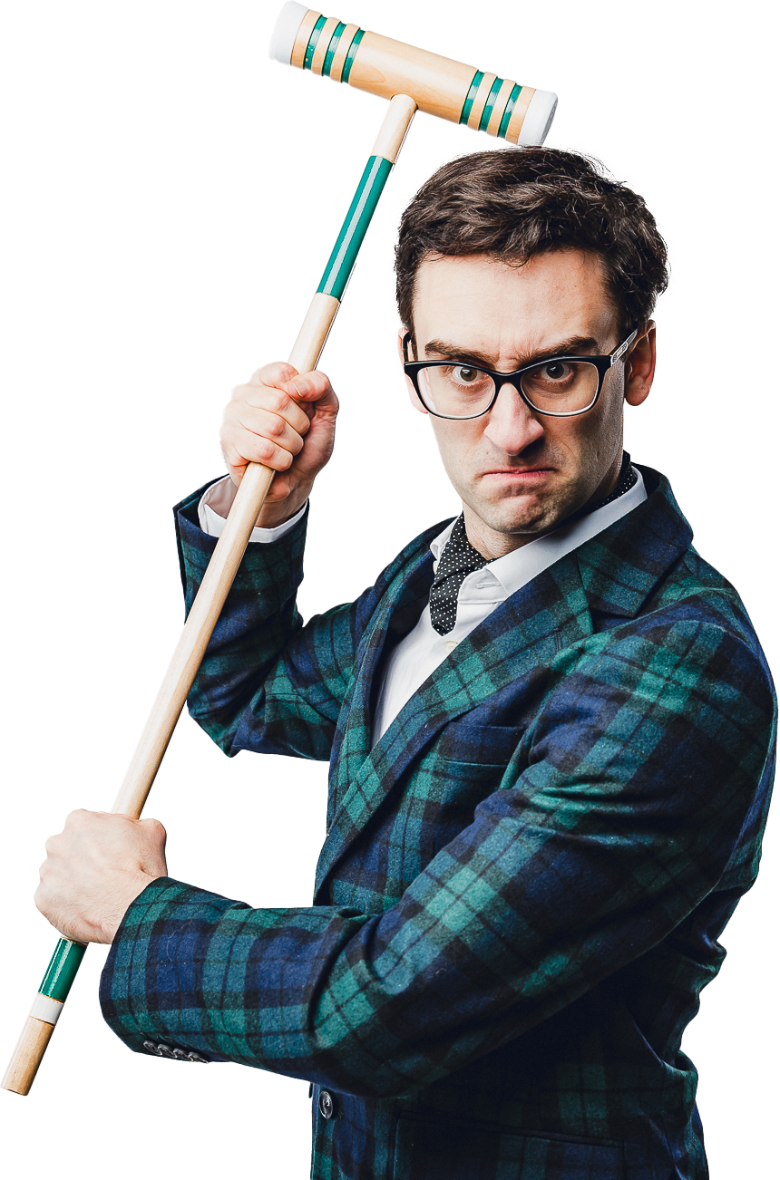A man wearing glasses and a plaid blazer, holding a croquet mallet, with a serious and intense expression.