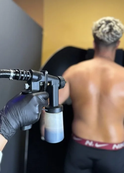 Person receiving a back tattoo with a tattoo machine