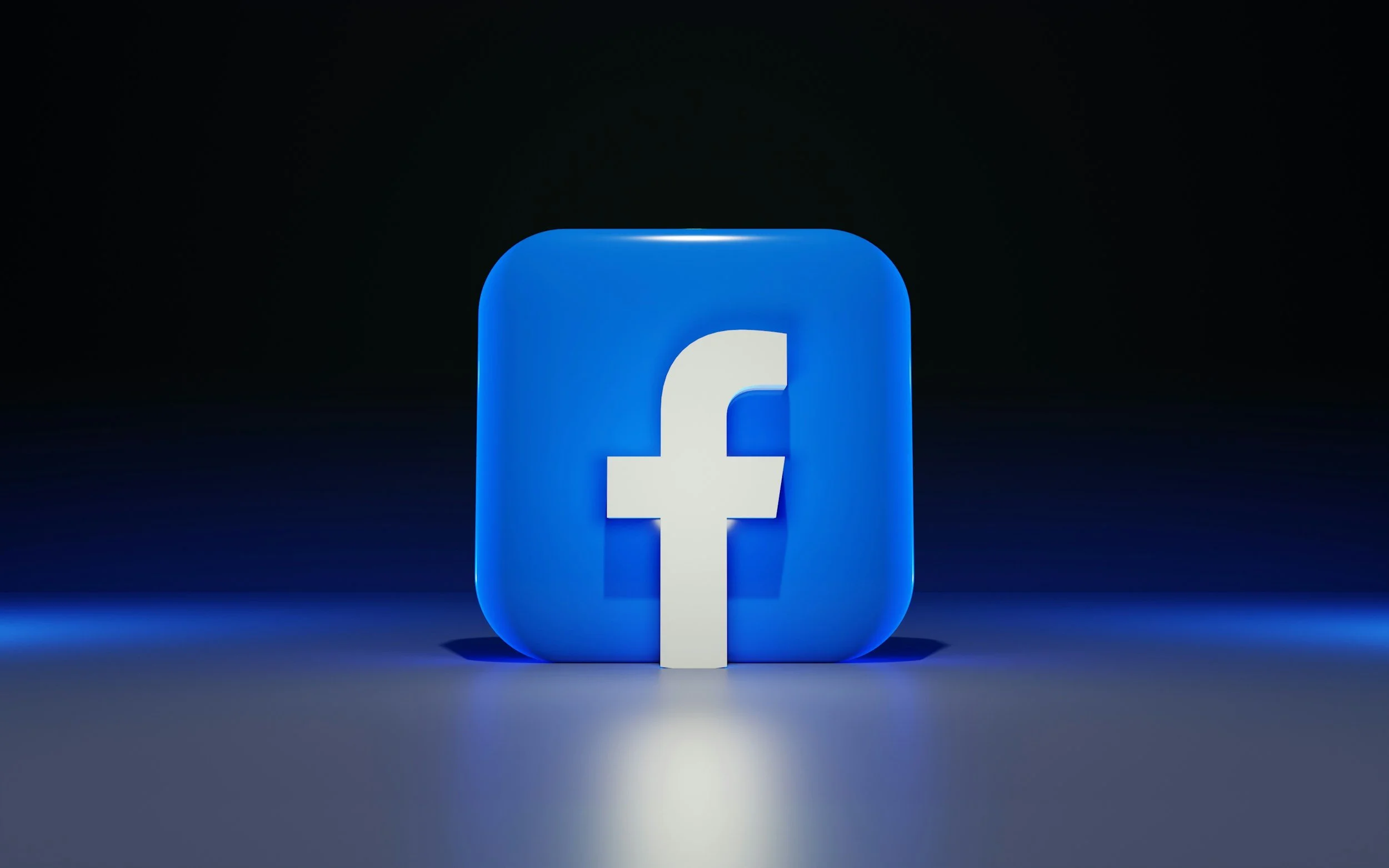 A glowing blue Facebook logo in a dark setting, illuminated from below.