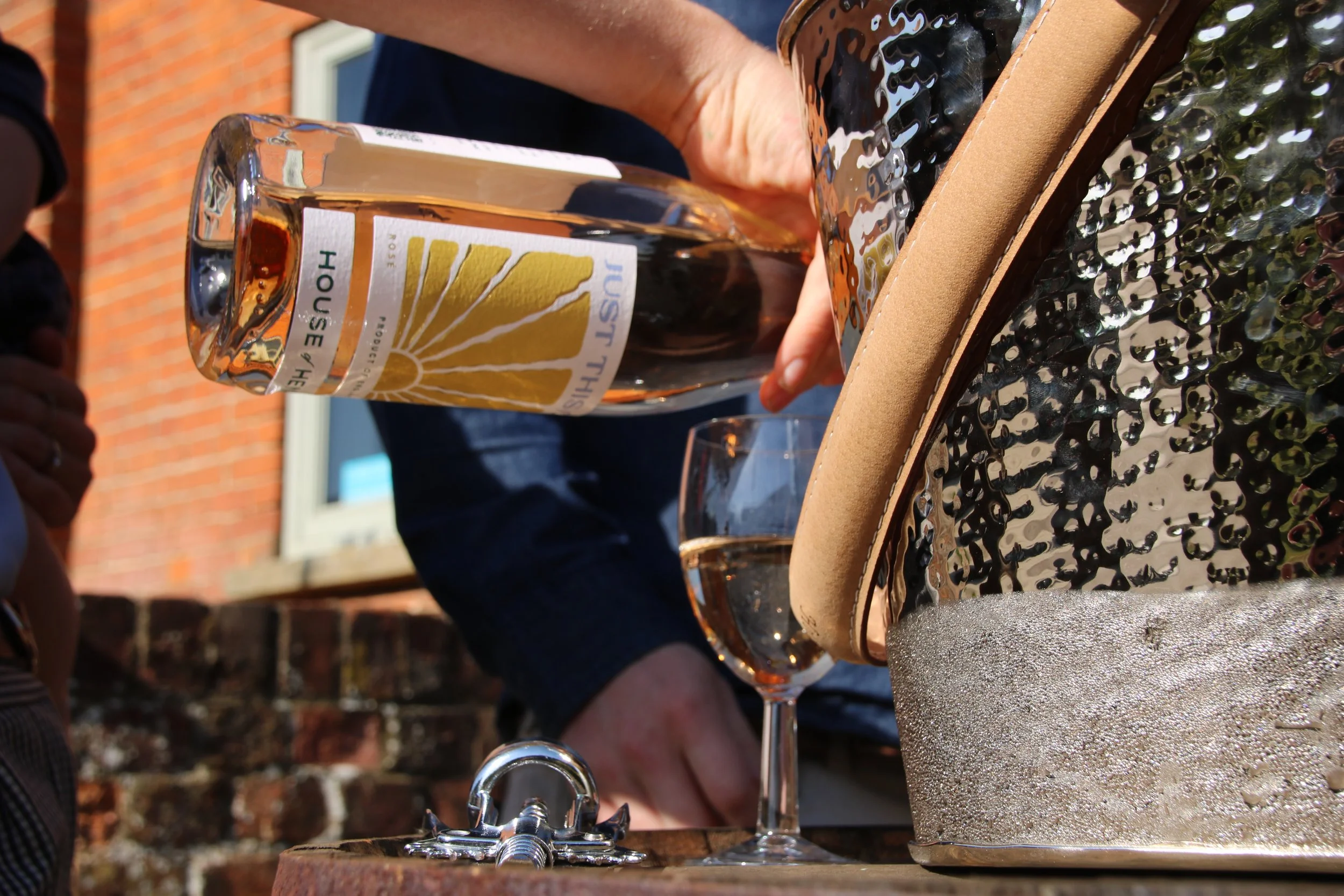 Close-up of a hand pouring premium English rosé wine from a vineyard near Stansted