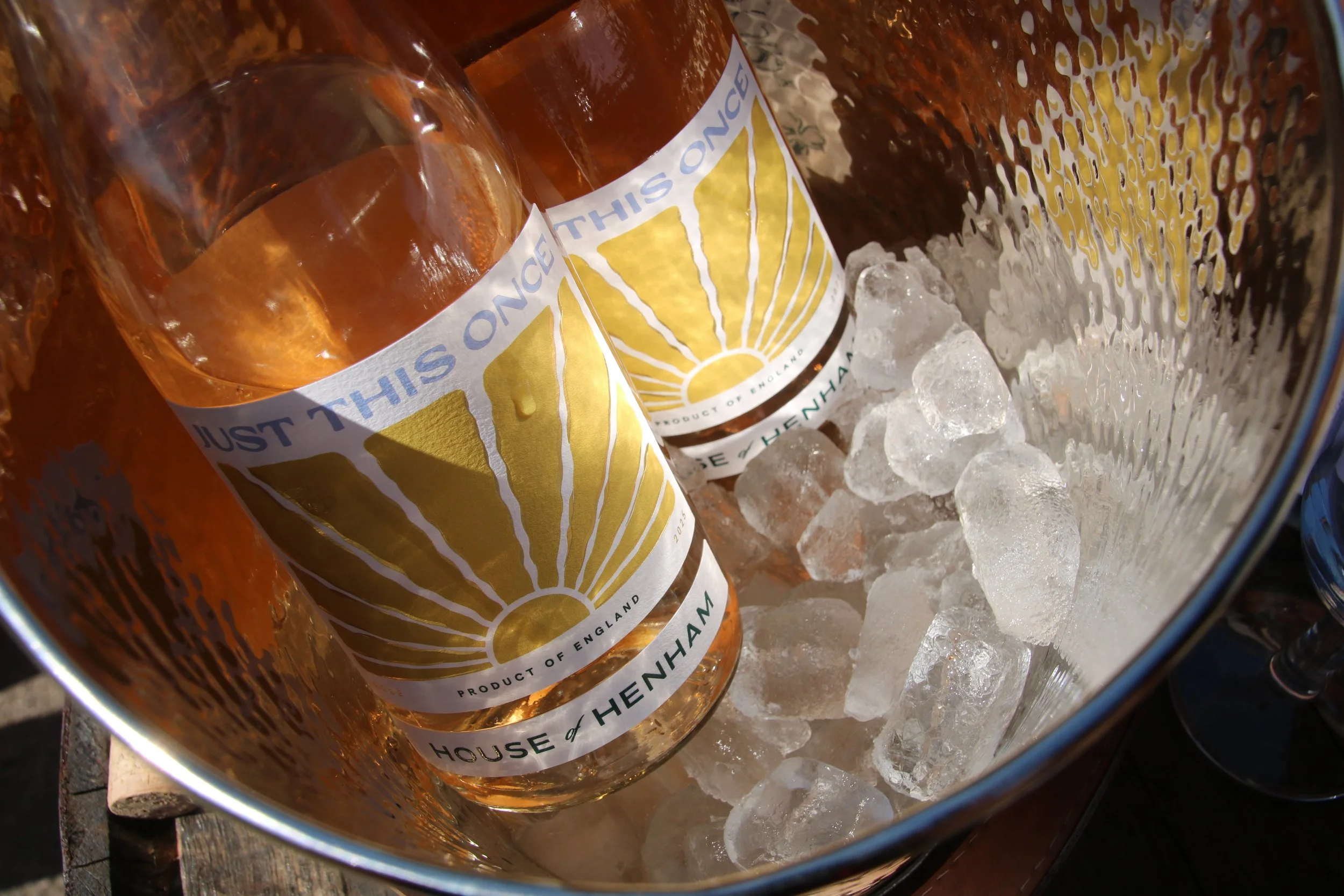 Two bottles of House of Henham rosé wine chilling in an ice bucket filled with ice cubes.