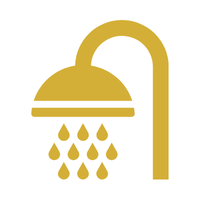 A gold shower head with water droplets falling from it.