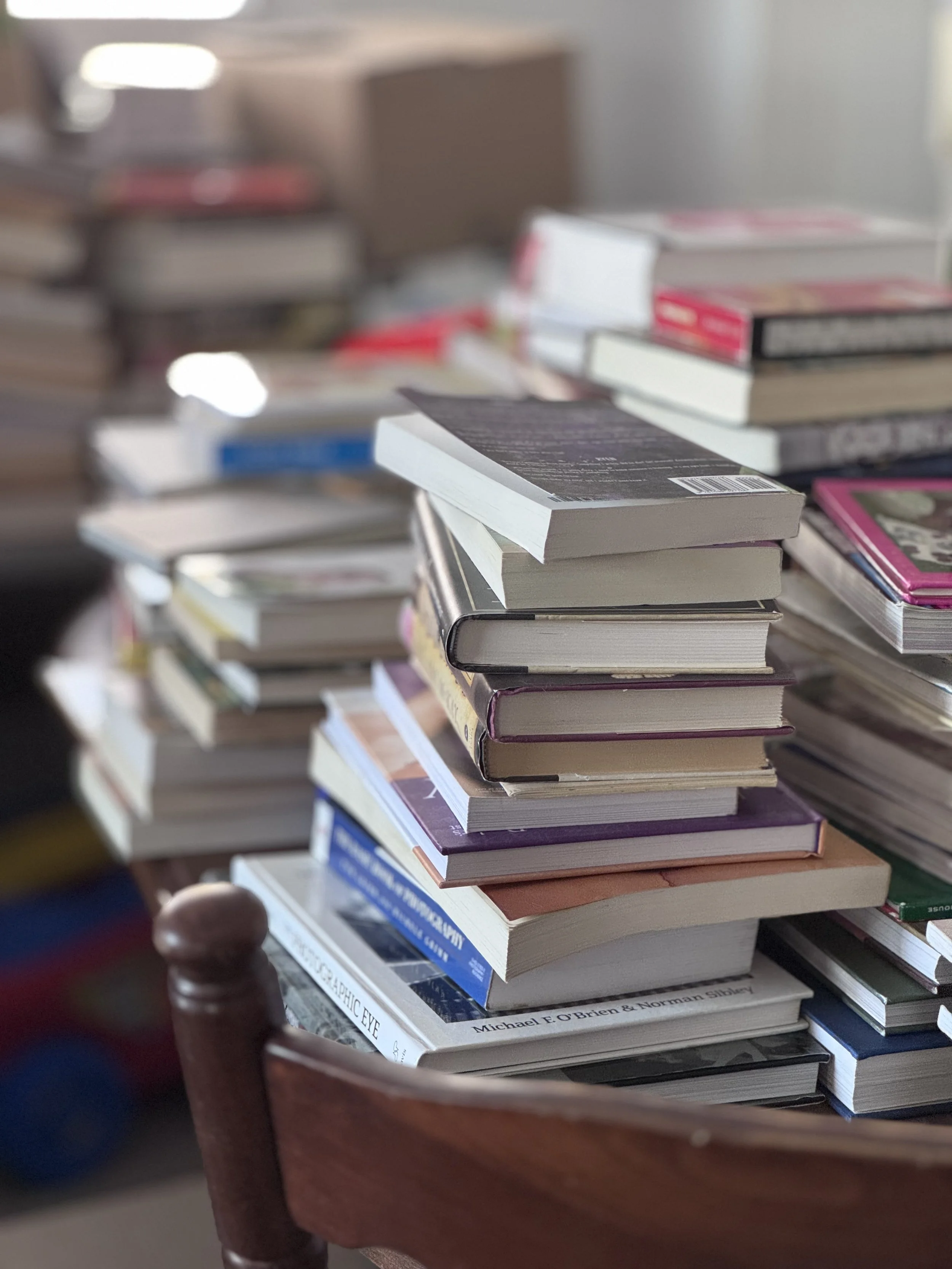Stack of books on a wooden chair.