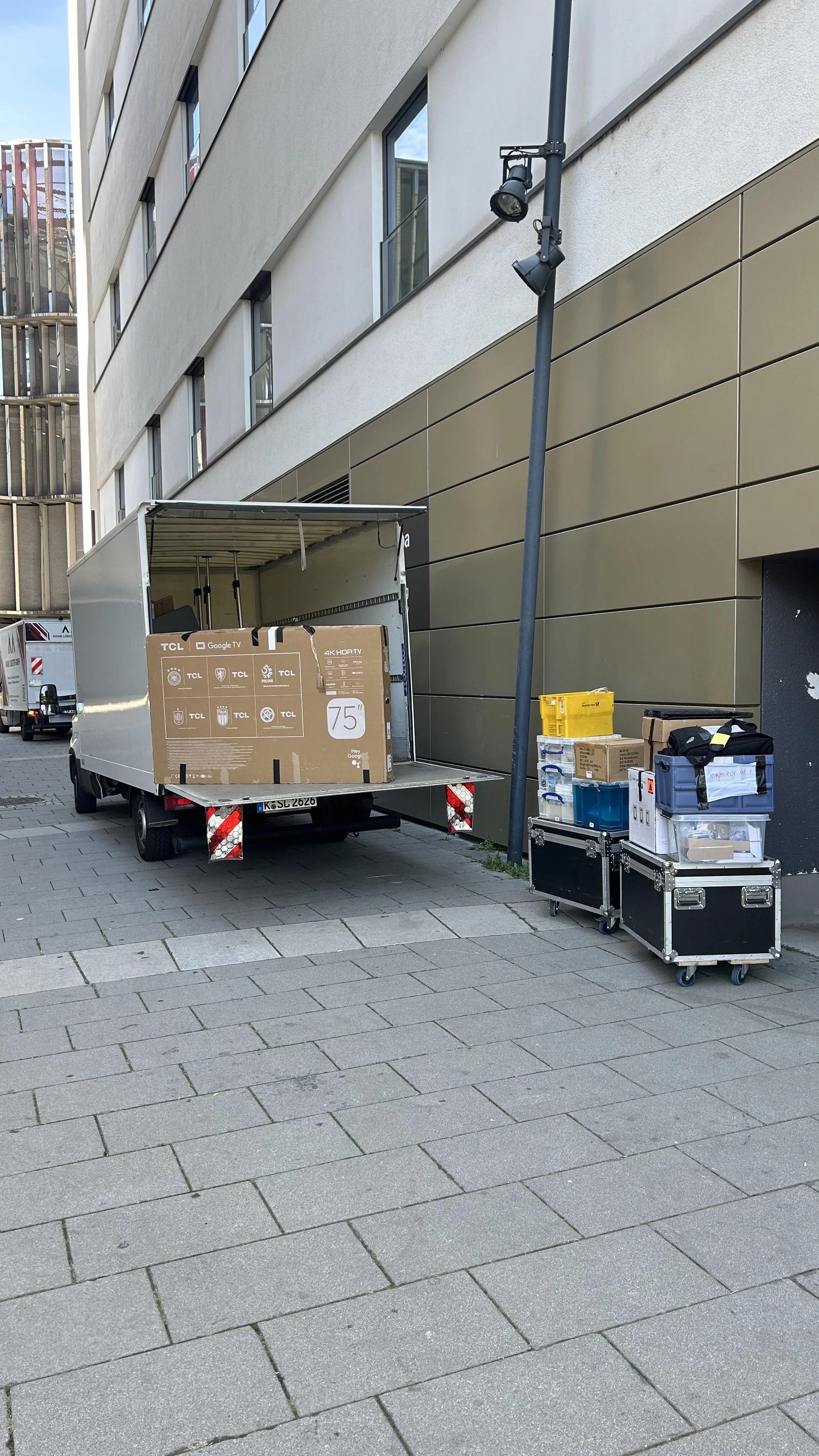 Mitarbeiter in einer Lagerhalle nutzt einen elektrischen Palettenroller, um große Kisten zu bewegen.