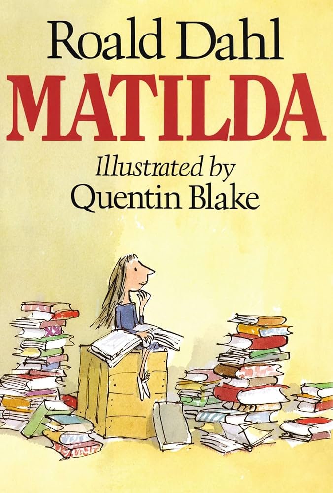 Book cover of 'Matilda' by Roald Dahl, illustrated by Quentin Blake, showing a girl sitting at a desk surrounded by stacks of books.