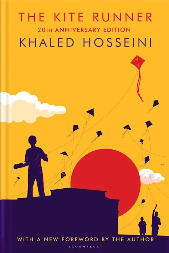 Book cover for 'The Kite Runner' by Khaled Hosseini, 20th anniversary edition, featuring a silhouette of a boy flying kites against a yellow background with clouds and a large red sun.
