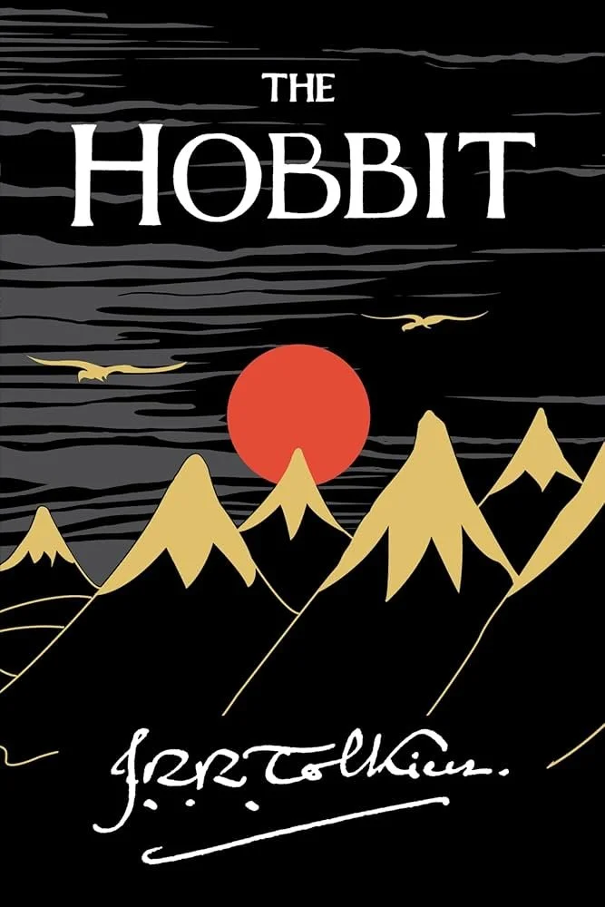 Stylized illustration of mountains with a large red sun, flying birds, and the text "The Hobbit" at the top and J.R.R. Tolkien's signature at the bottom.