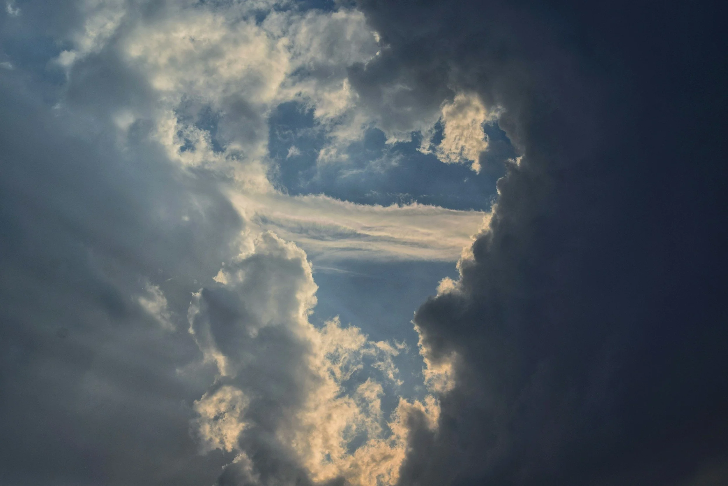 Ciel avec des nuages sombres et certains éclairages du soleil derrière