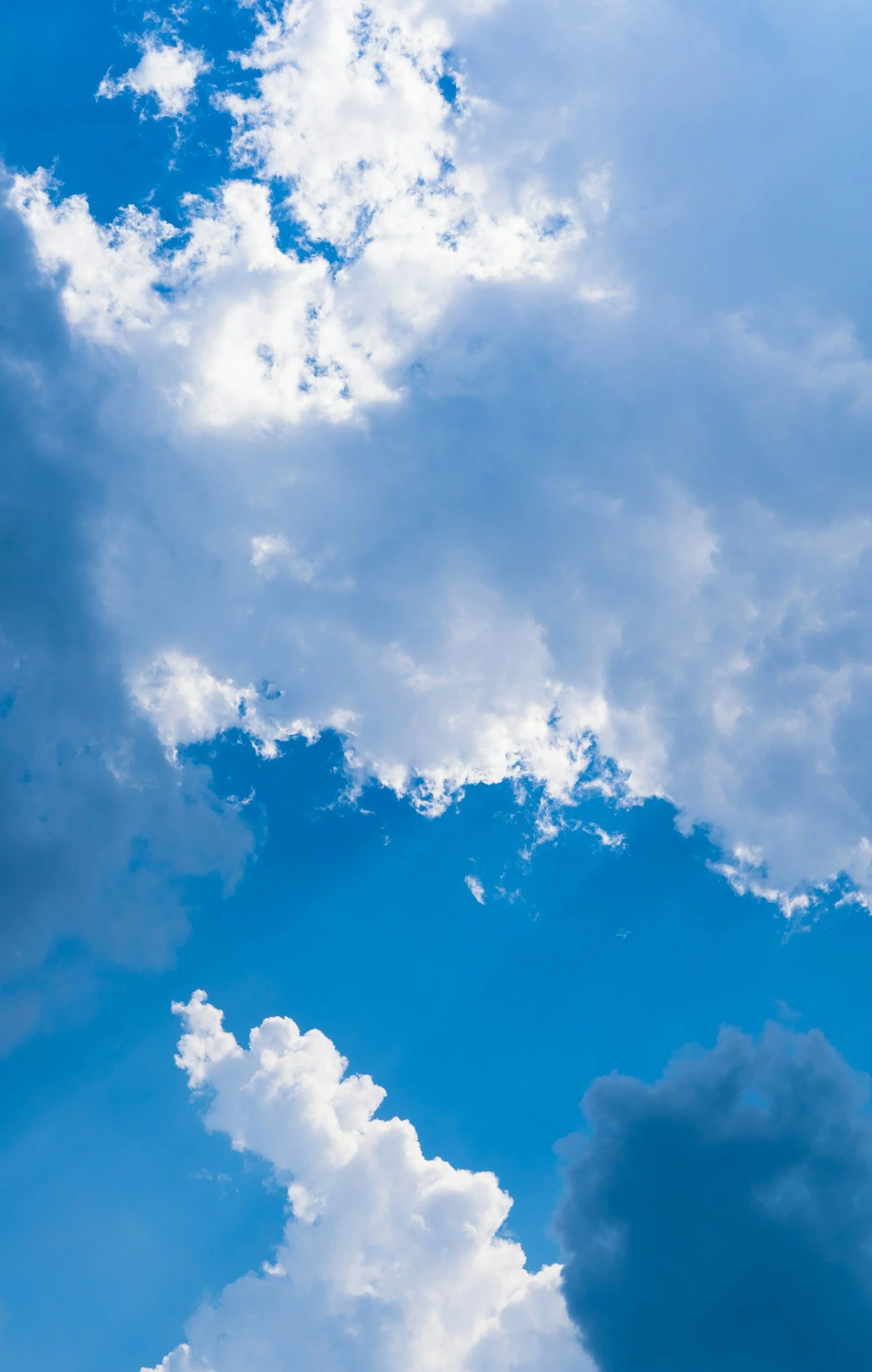 Ciel bleu avec des nuages blancs et duveteux.