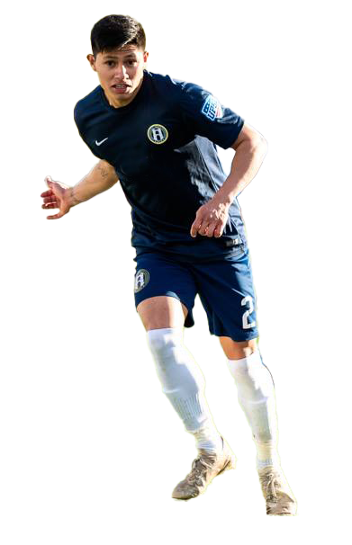 A young male soccer player in a navy blue uniform running on the field.