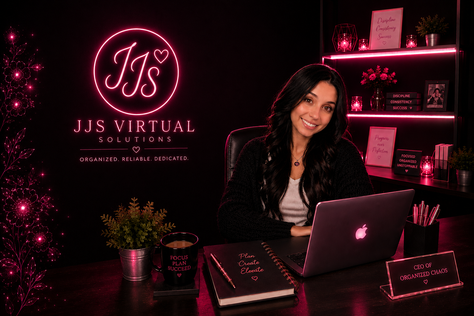 A woman sitting at a desk with a pink and black decor. Behind her, there is a black wall with a pink neon sign that reads 'JJS VIRTUAL SOLUTIONS' and additional text. The desk has a laptop, a notebook, a pen, a mug with motivational text, and a small plant. In the background, there are shelves with decorative items, framed quotes, and pink lighting.