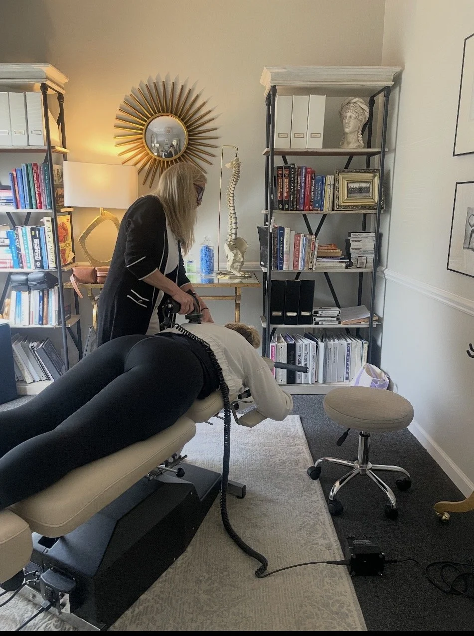 chiropractor percussing patient before adjustment