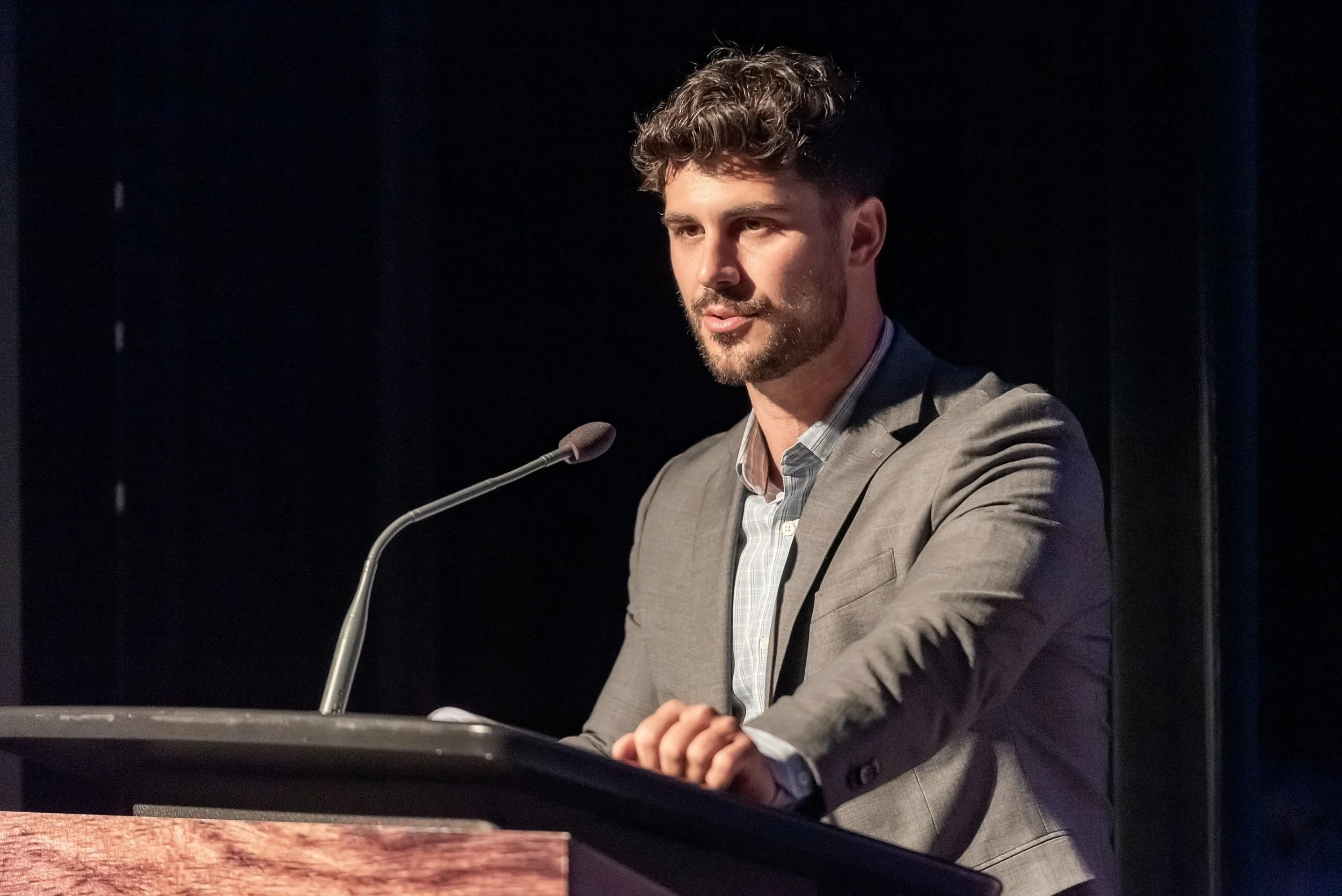Kevin Avgenikos prenant la parole lors d'une conférence — courtier immobilier et conferencier sur les dynamiques familiales en immobilier