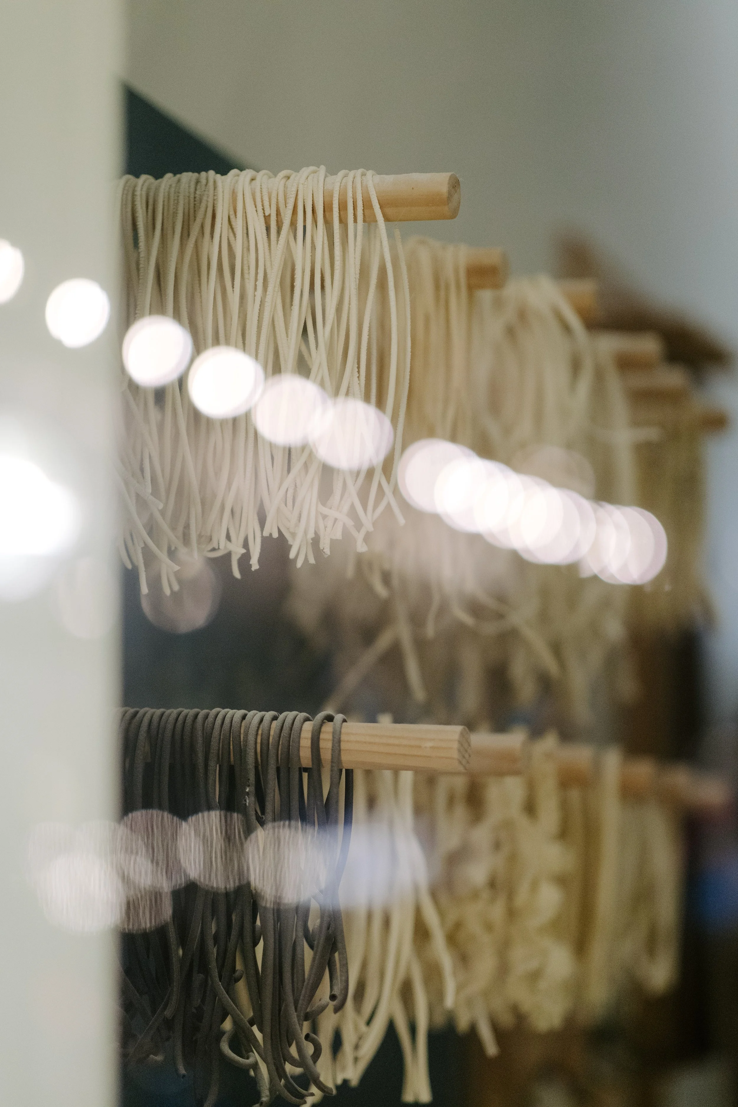 Close-up of multiple rolls of stretchy fabric or elastic bands hanging on wooden rods in a retail display.