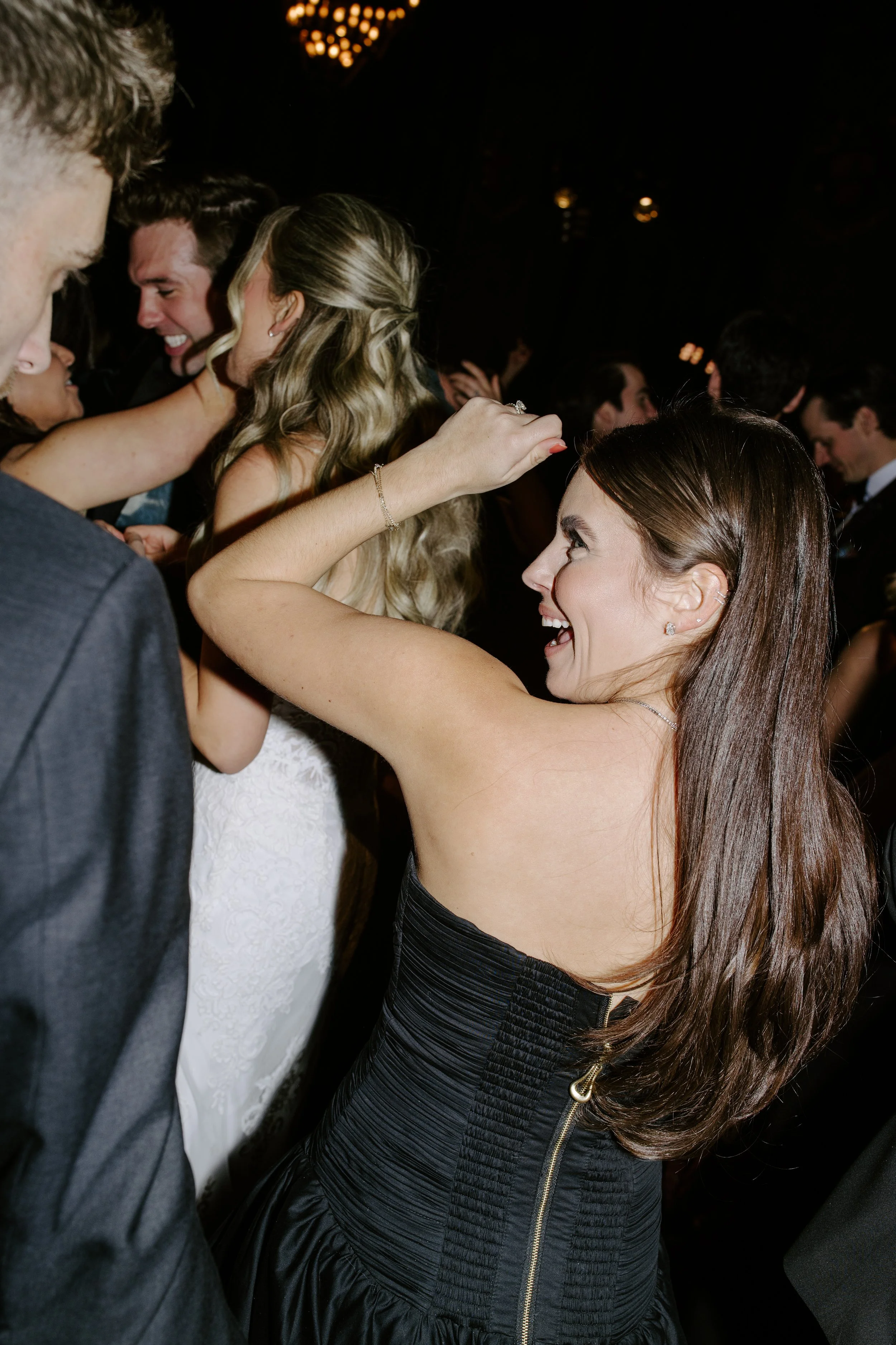 People dancing and celebrating at a formal event or party, smiling and enjoying themselves.