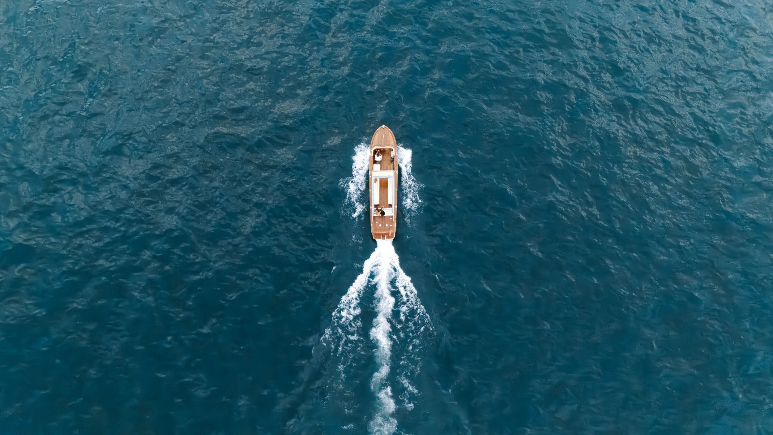 A boat moving through the water, creating a trail of white foam behind it.