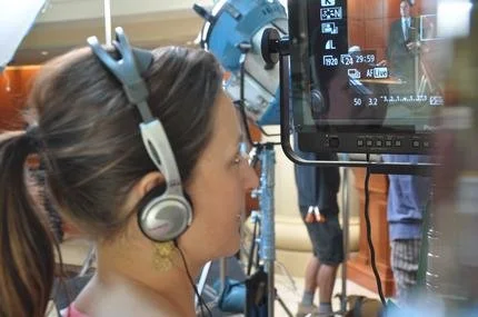 Erin McCahill watching the monitor feed while filming and directing on location with subject matter experts